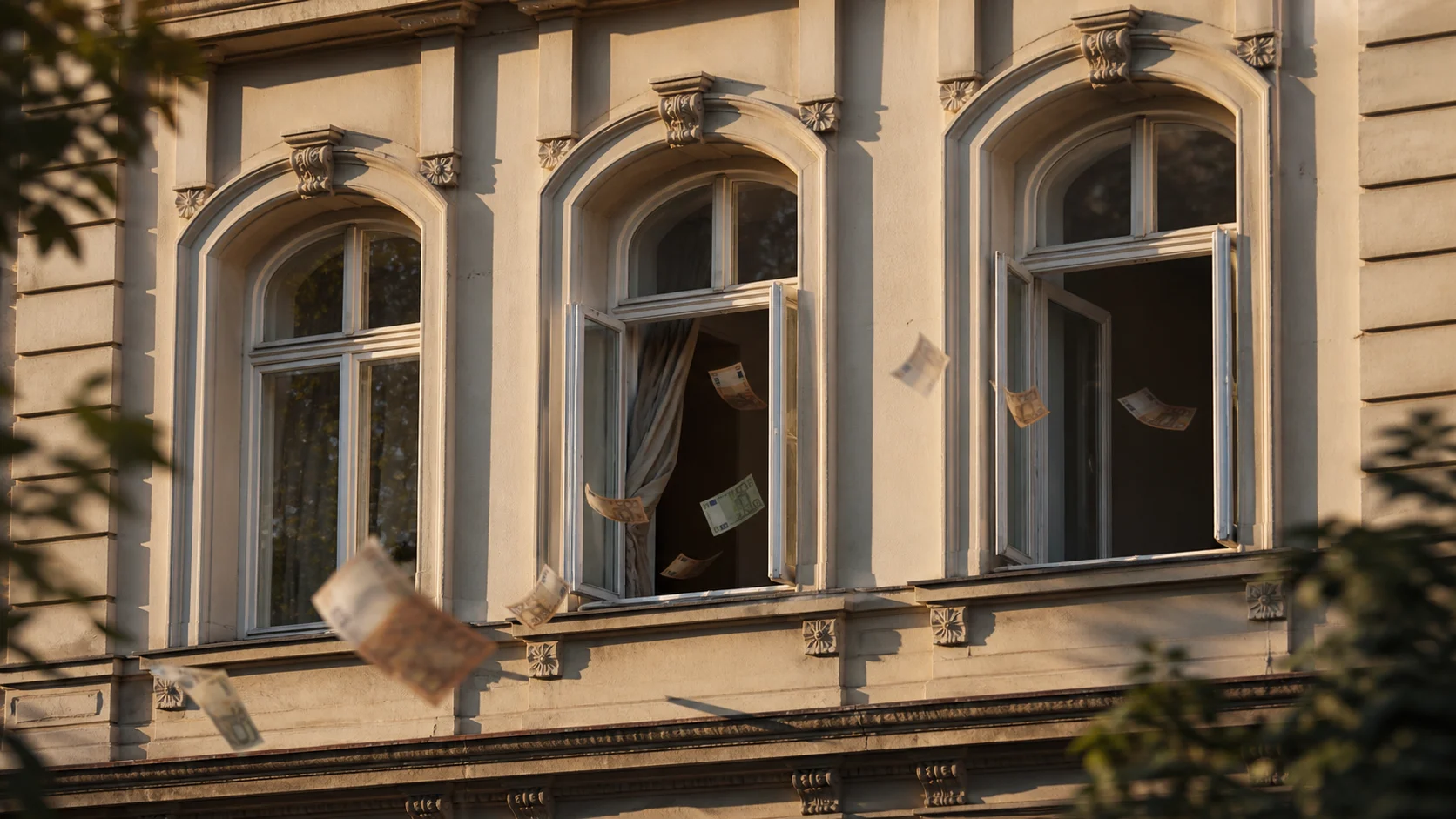 Gründerzeitgebäude mit aus dem Fenster fliegenden Euroscheinen – Symbol für entgangene Mieteinnahmen durch illegale Untervermietung